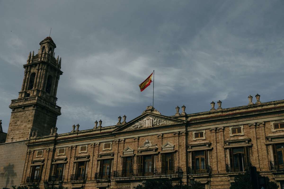 Edificio de la Administración con la bandera de España: reclamación por abuso de temporalidad de interinos