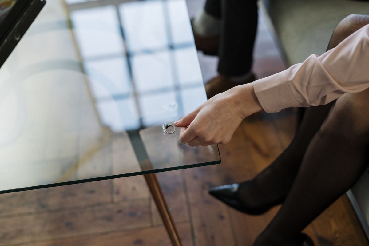 Anillo de boda dejado sobre una mesa de cristal tras una ruptura