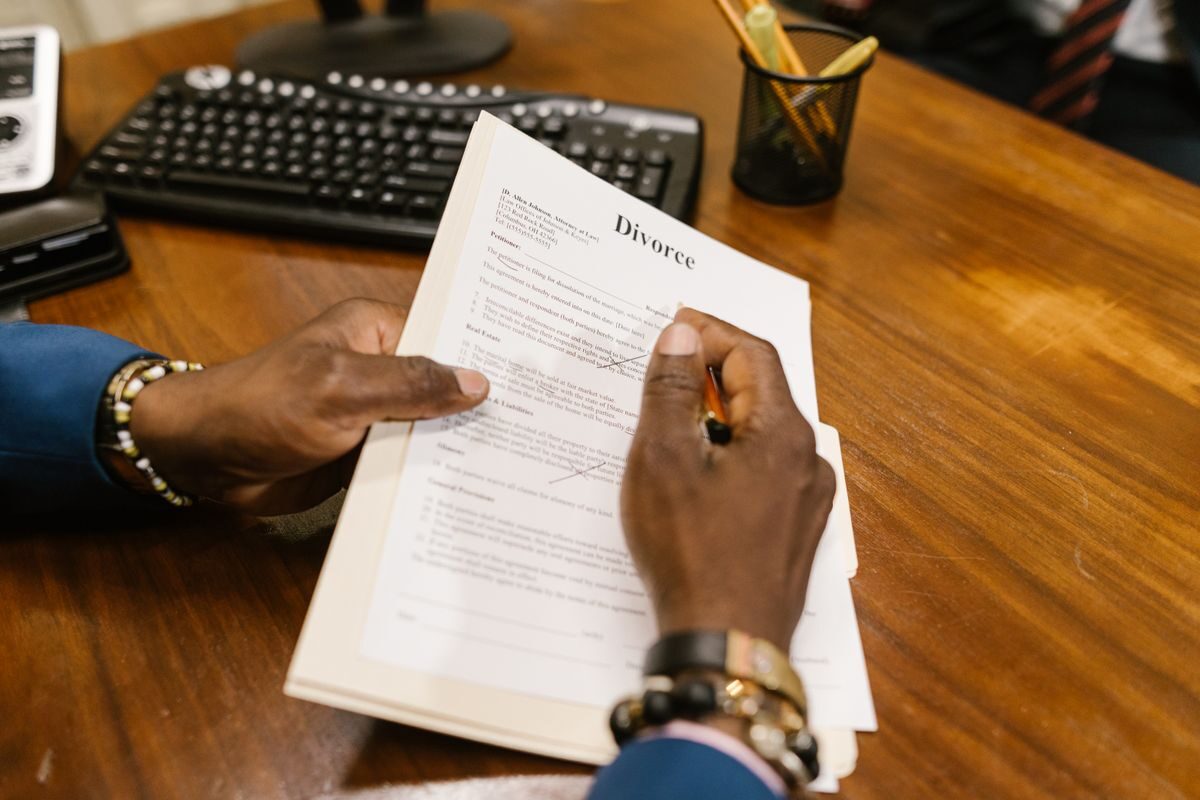 Hands holding a divorce document at a desk