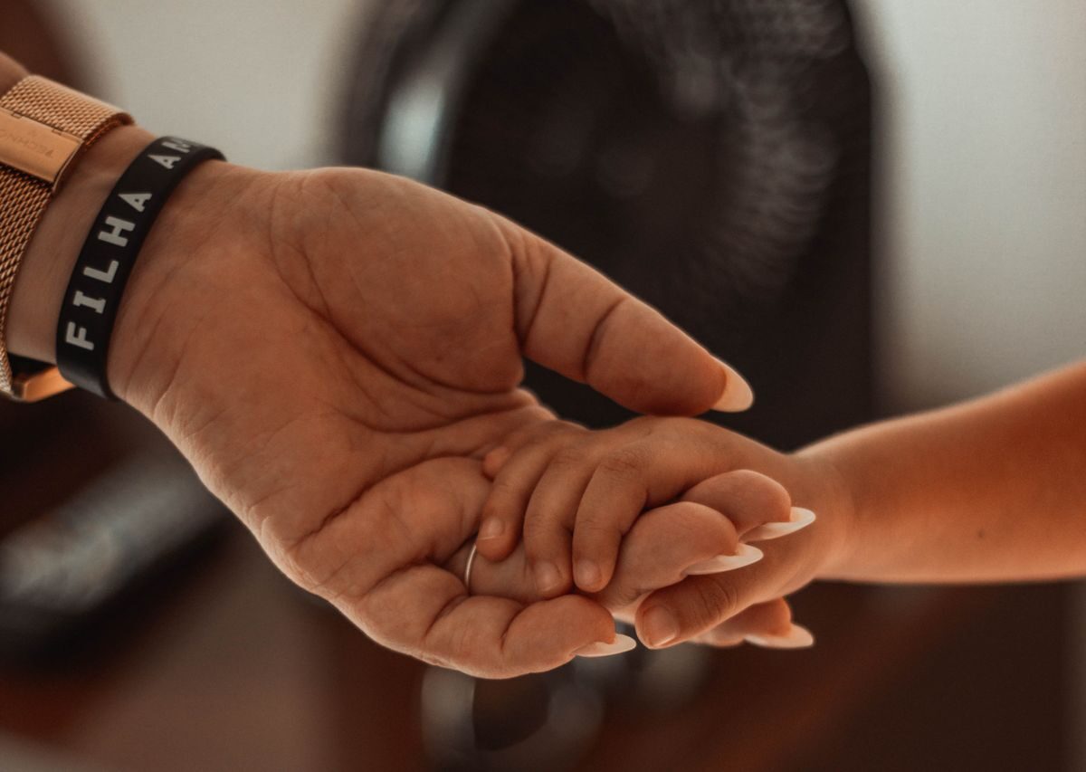 Mano de un adulto sosteniendo la mano de un niño